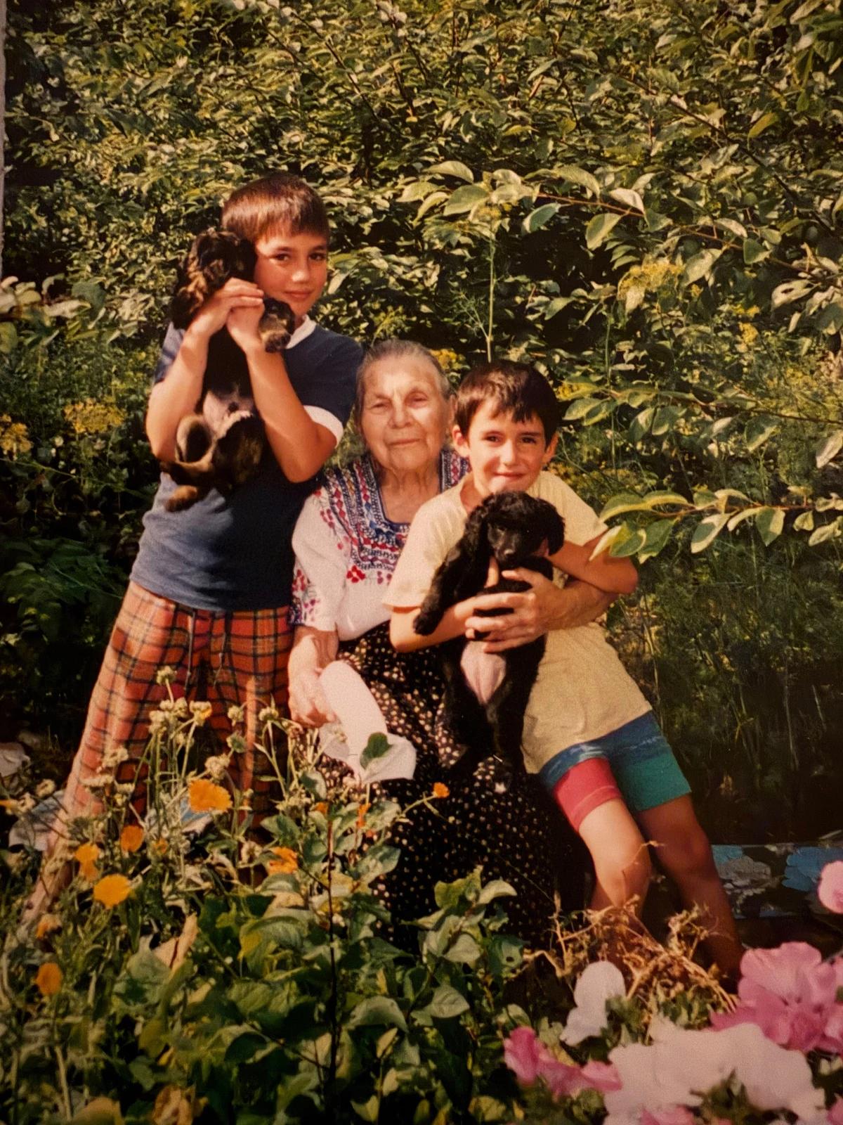 Denis with his first dog and family in a garden in the early 2000s