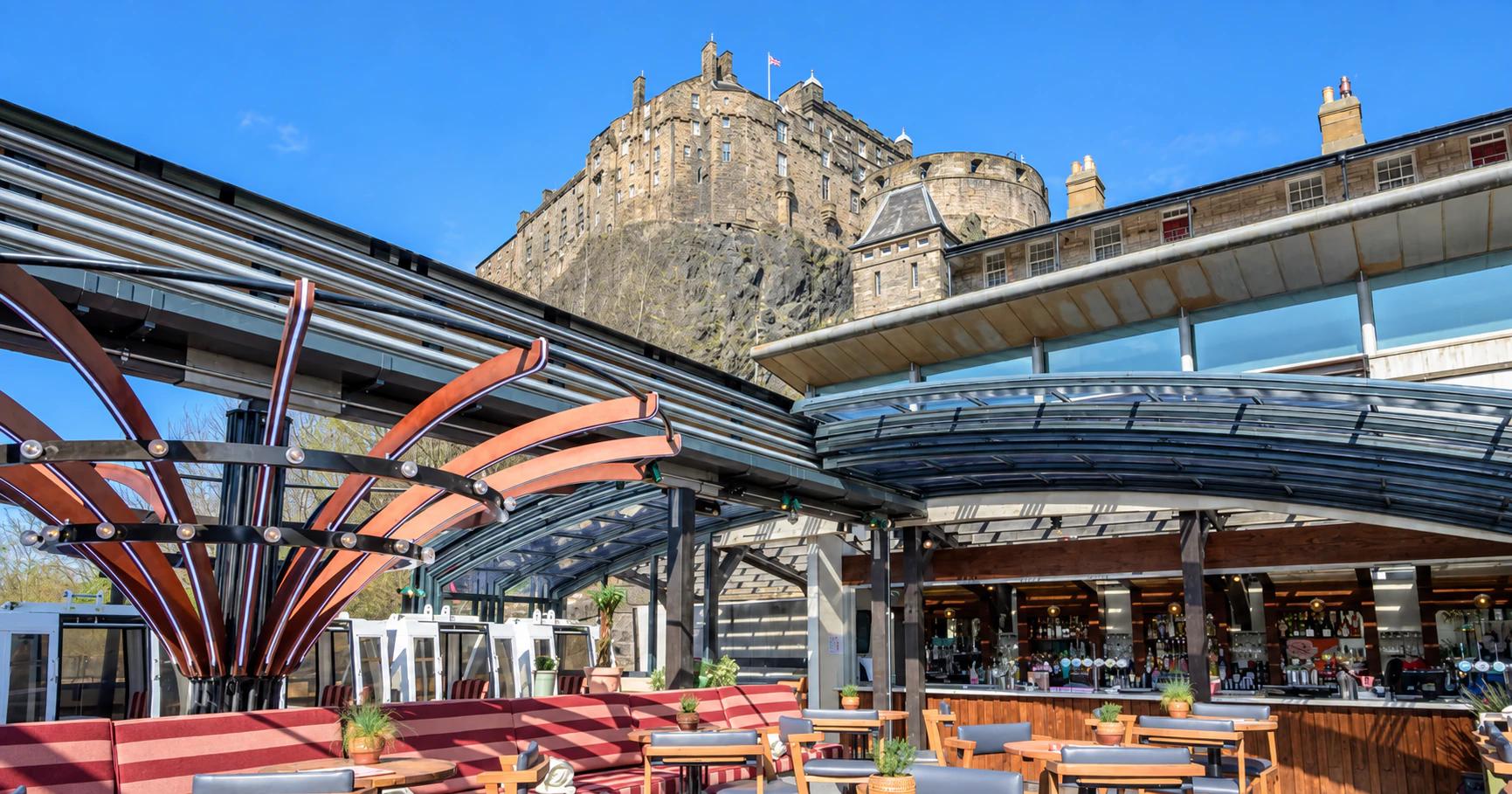 Sunlit rooftop tables at Cold Town House beneath Edinburgh Castle