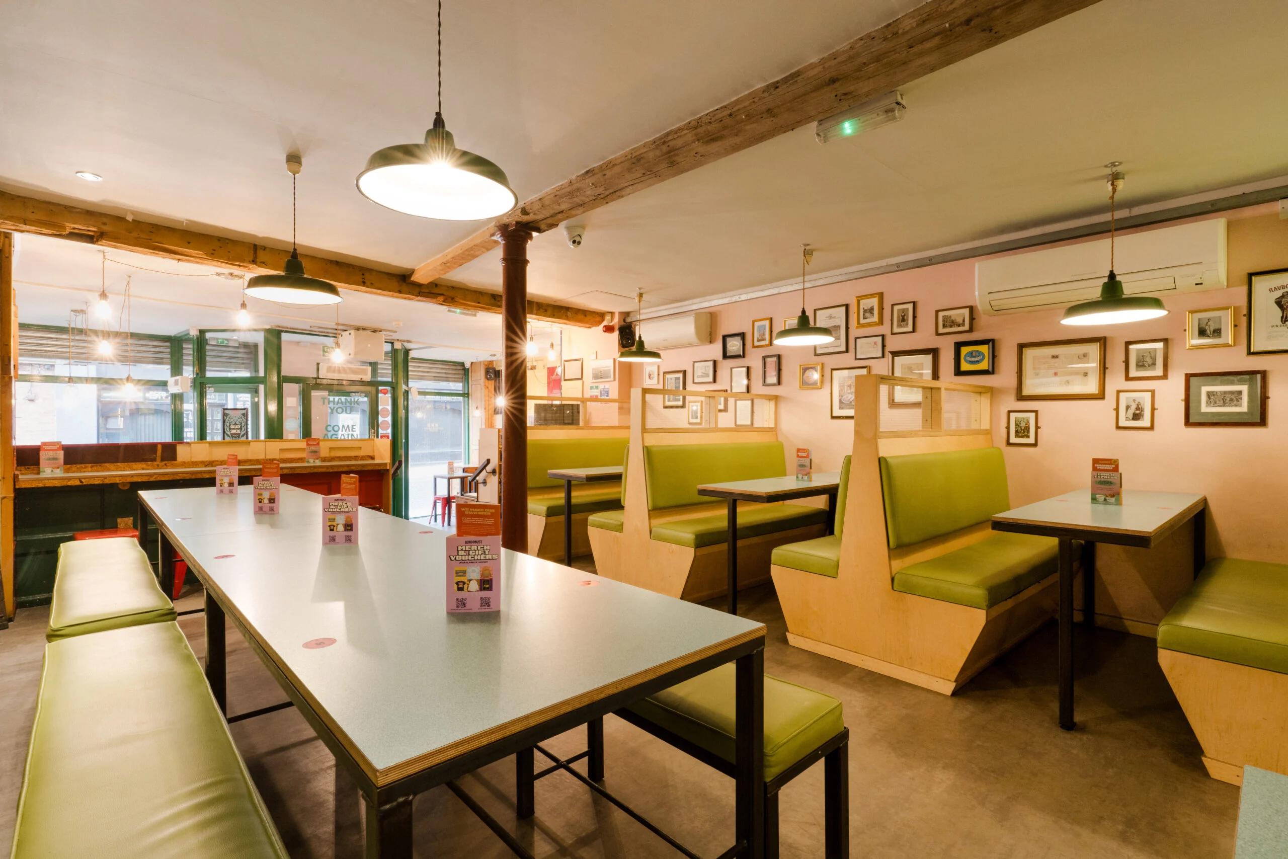 Tables and green booth seating inside Bundobust Leeds