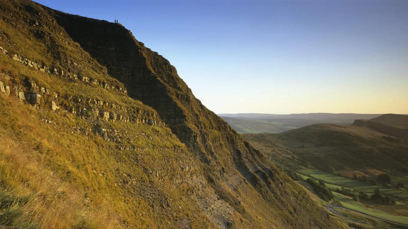 Sunlit slopes of Mam Tor above the valley