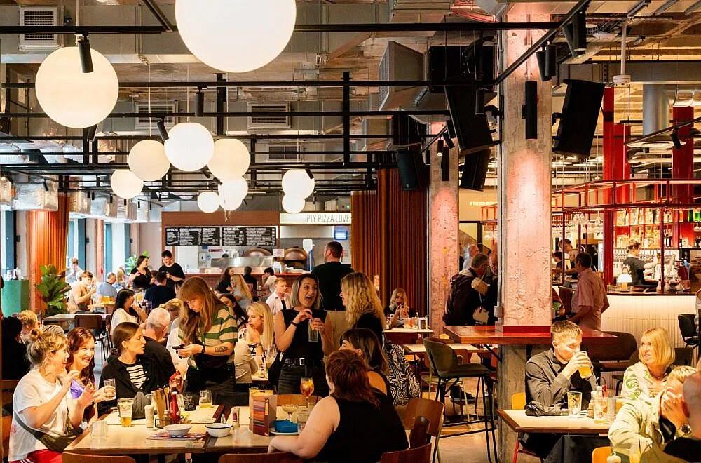 Diners beneath globe lights inside New Century Kitchen