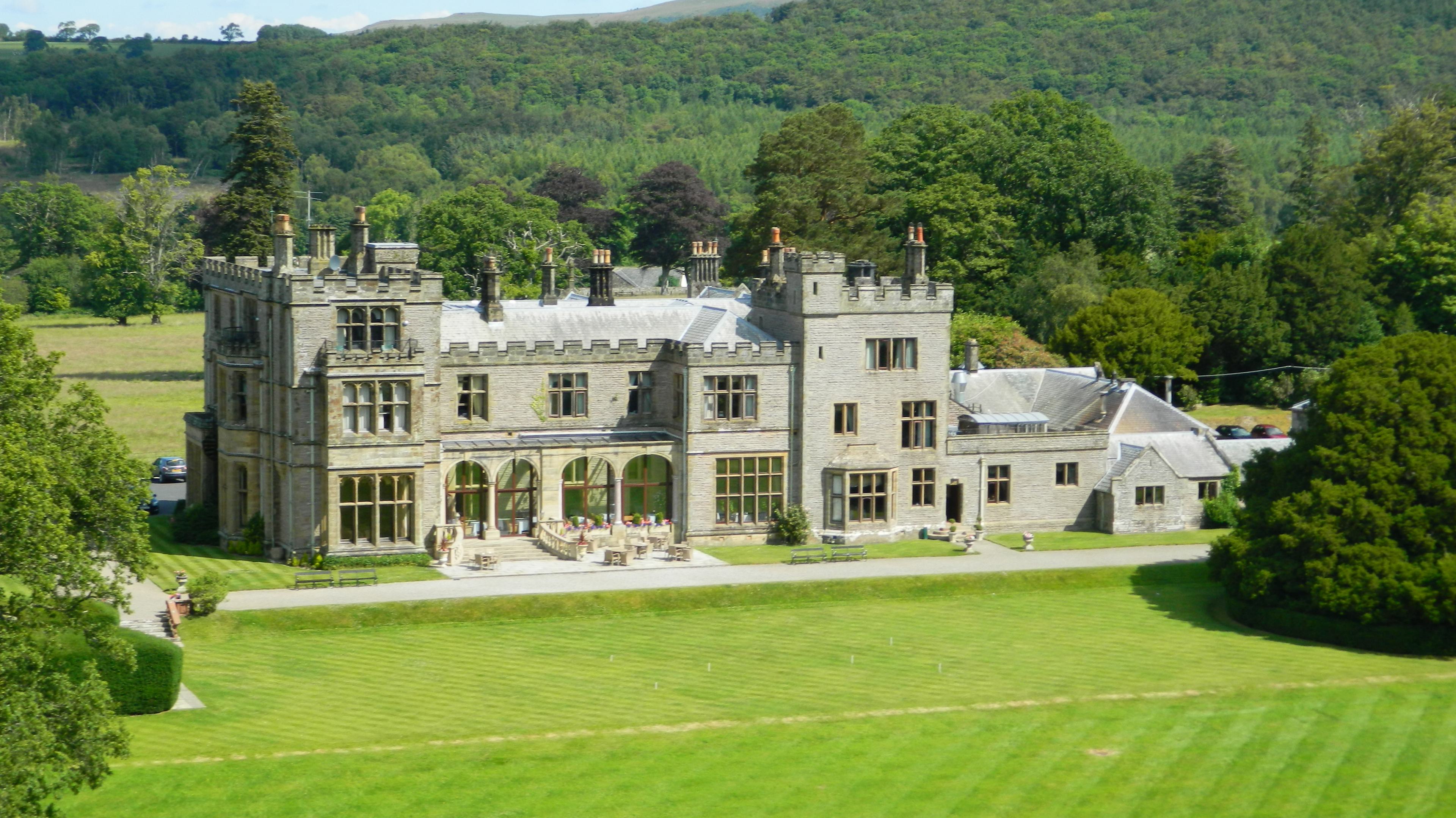 Stone frontage of Armathwaite Hall beneath a blue sky
