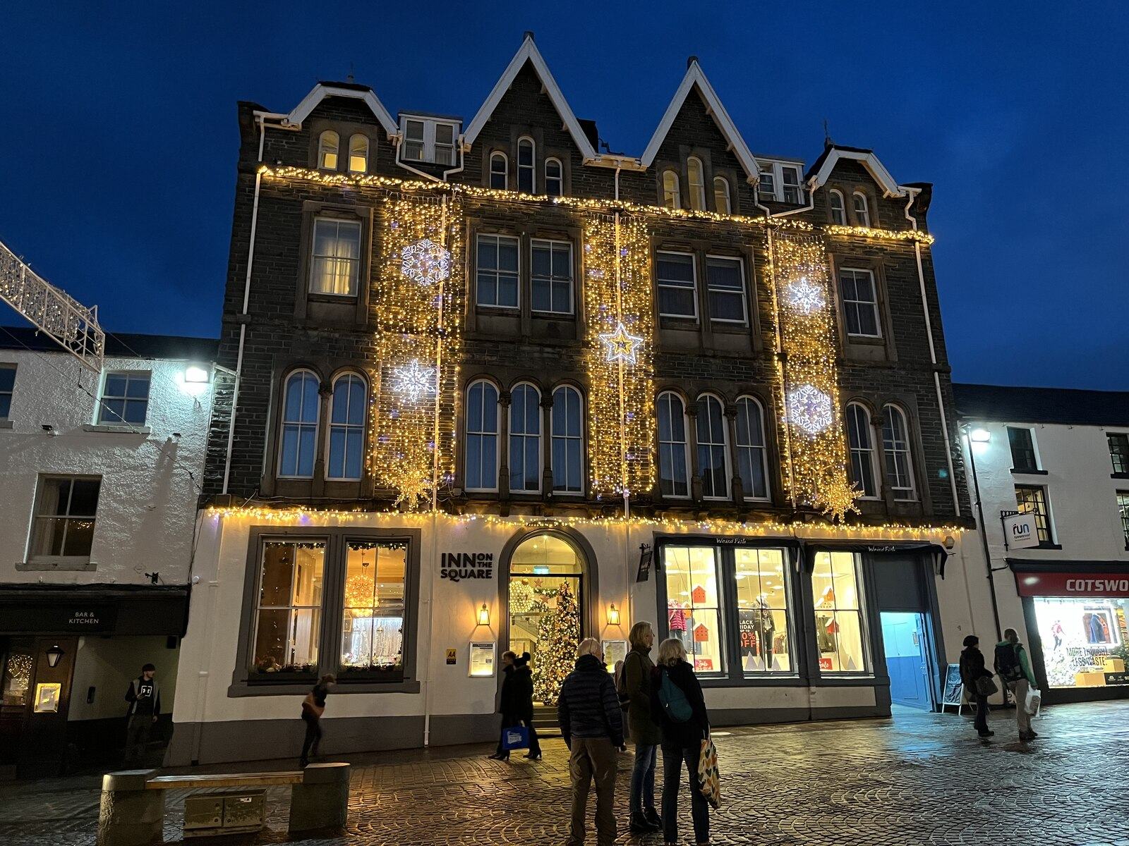 The illuminated frontage of Inn on the Square in central Keswick