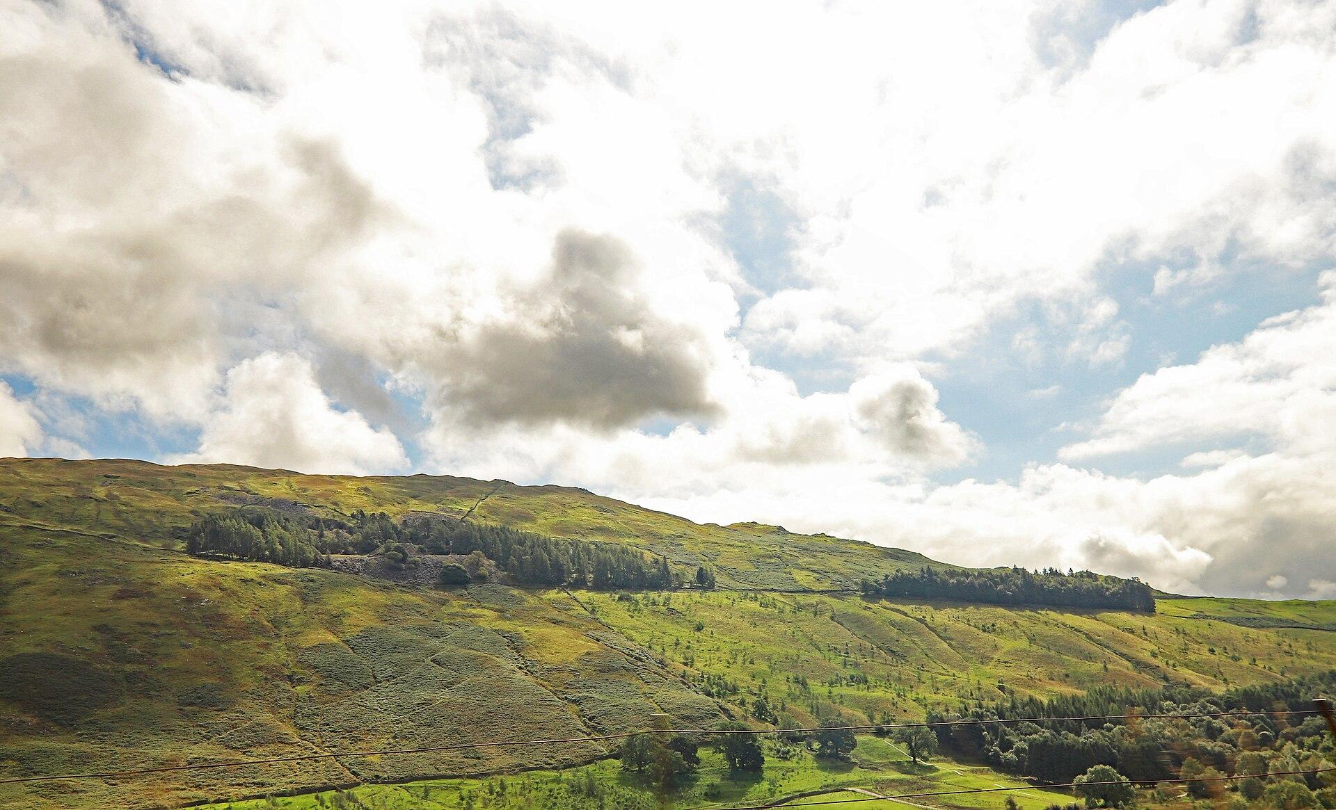 Green Lake District hills beneath sunlit clouds