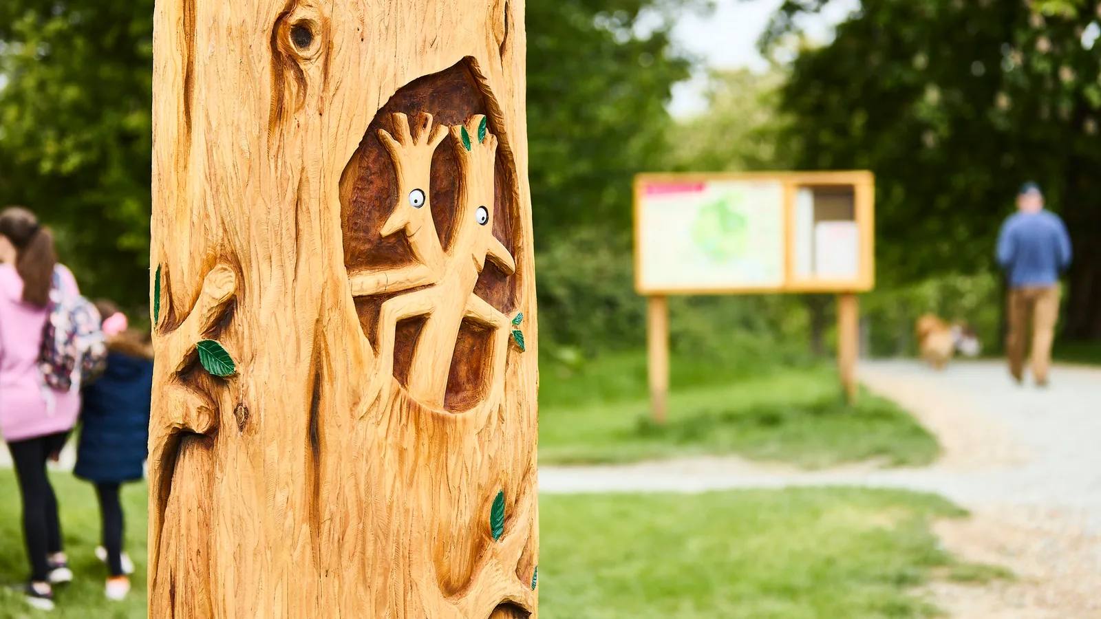 A carved woodland marker beside a path at Weald Country Park