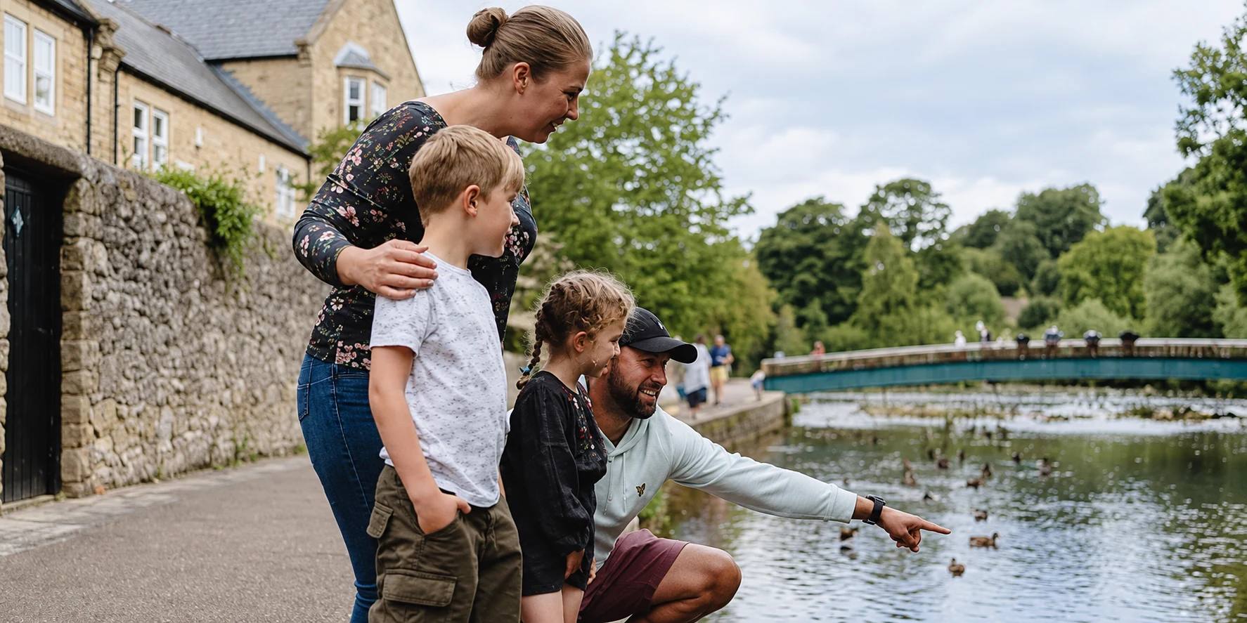 Adults and children beside the River Wye in Bakewell