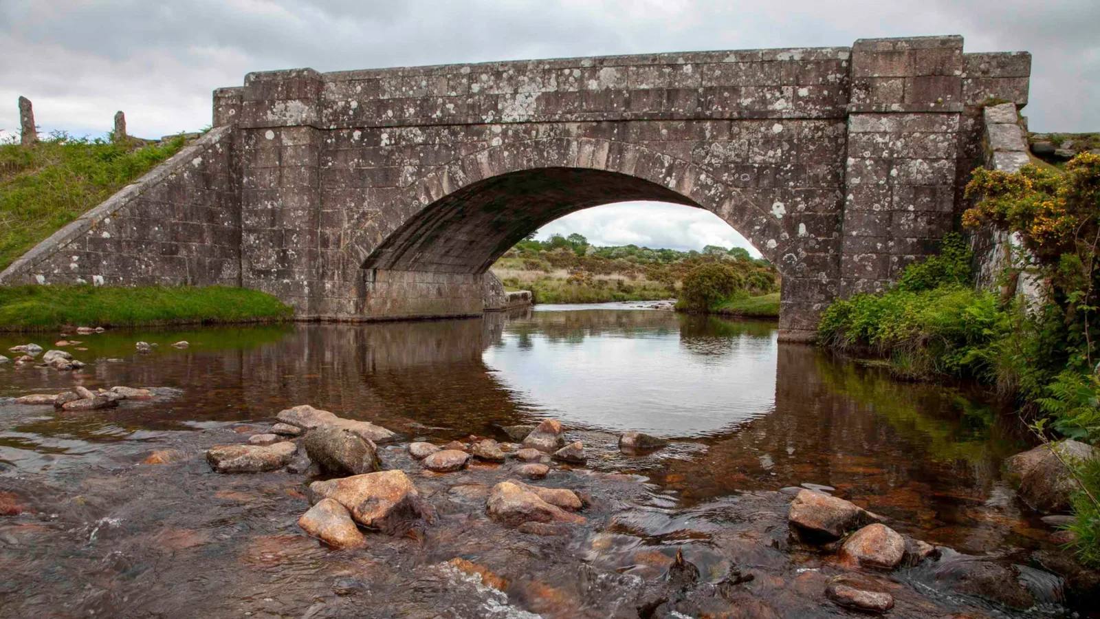 Cadover Bridge spanning the shallow River Plym between moorland banks