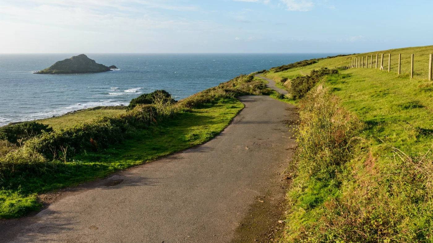 The tarmac trail at Wembury Point descending towards the sea and Great Mewstone