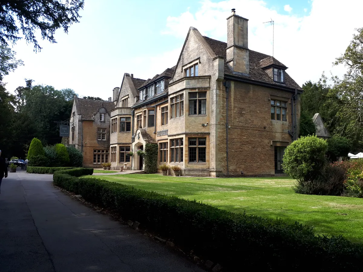 The stone frontage and gardens of The Hare and Hounds at Westonbirt