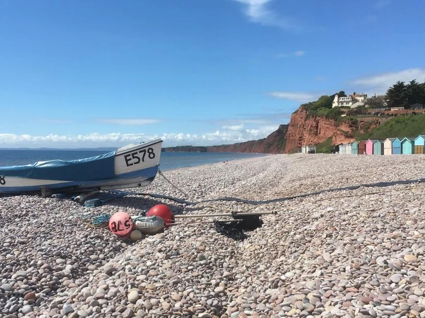 Boats and beach huts on Budleigh Salterton’s pebble beach, an area overview