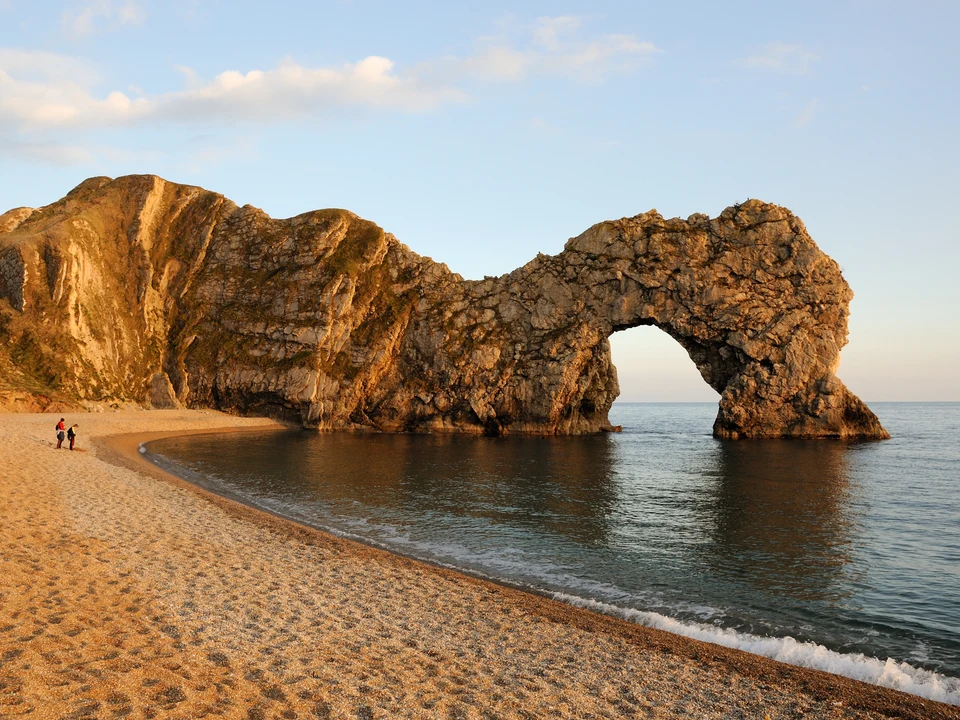 Durdle Door rock arch and shingle beach in evening light