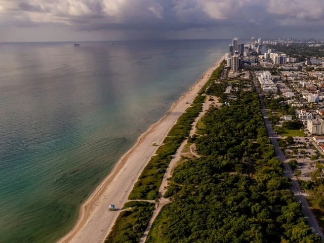 Aerial view of North Beach Oceanside Park's broad shoreline and coastal greenery in Miami Beach.