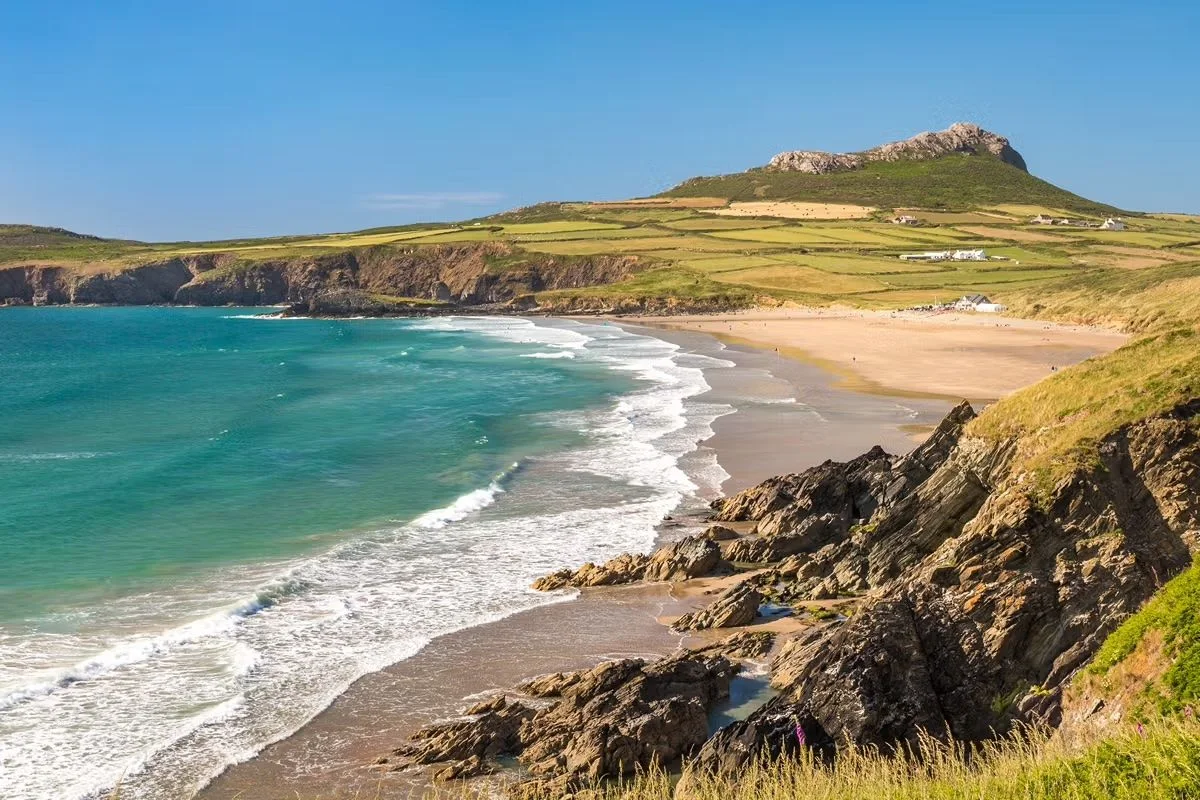 Whitesands Bay curving below Carn Llidi and rocky cliffs