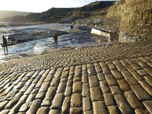 Cobbled slipway meeting the rocky shore at Robin Hood’s Bay