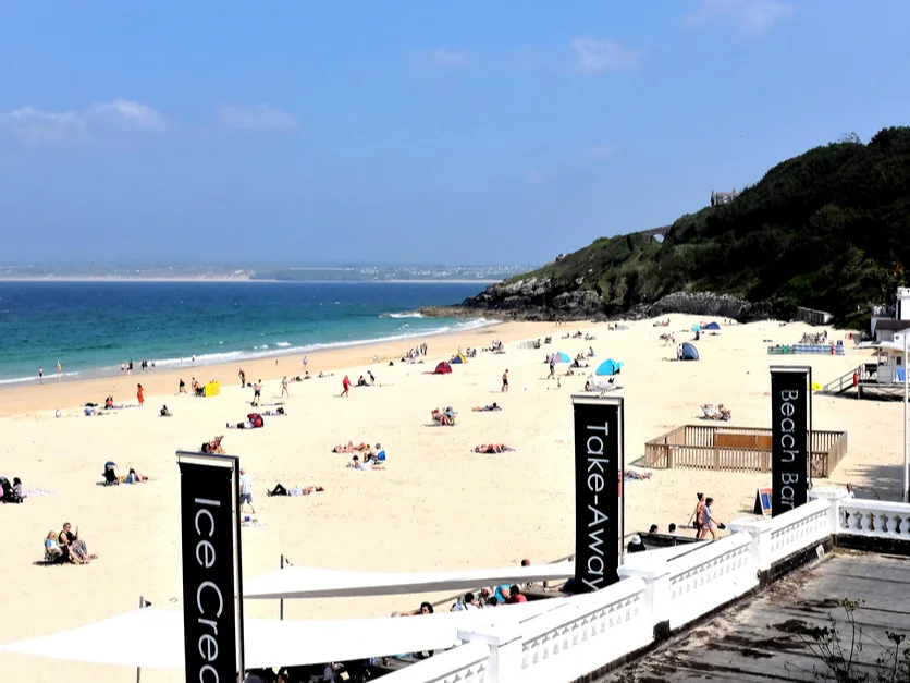 Porthminster Beach with a seafront terrace and wooded headland.