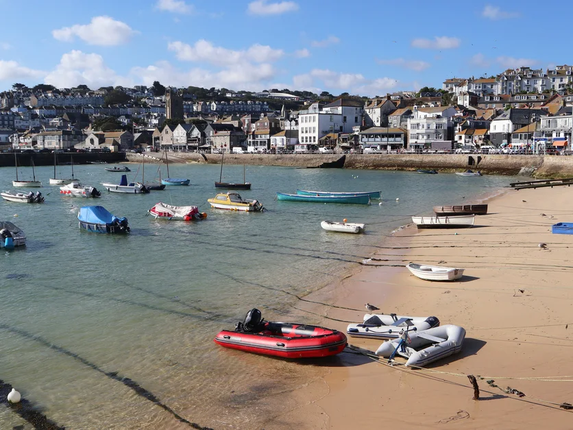 St Ives Harbour Beach at low tide, with boats and waterfront buildings.