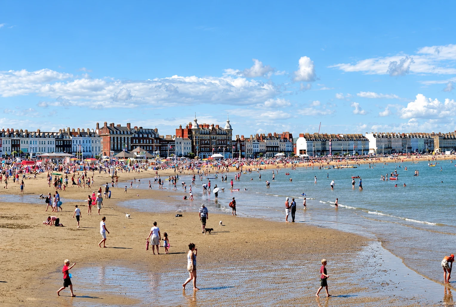 Families on the broad sandy beach beside Weymouth seafront