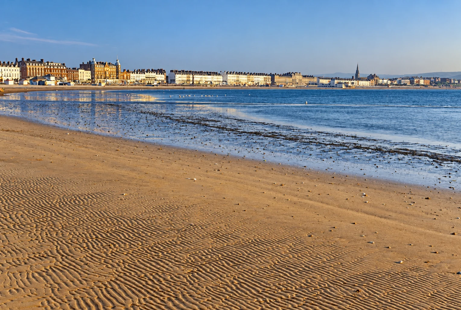 Golden sand and seafront buildings at Weymouth Beach