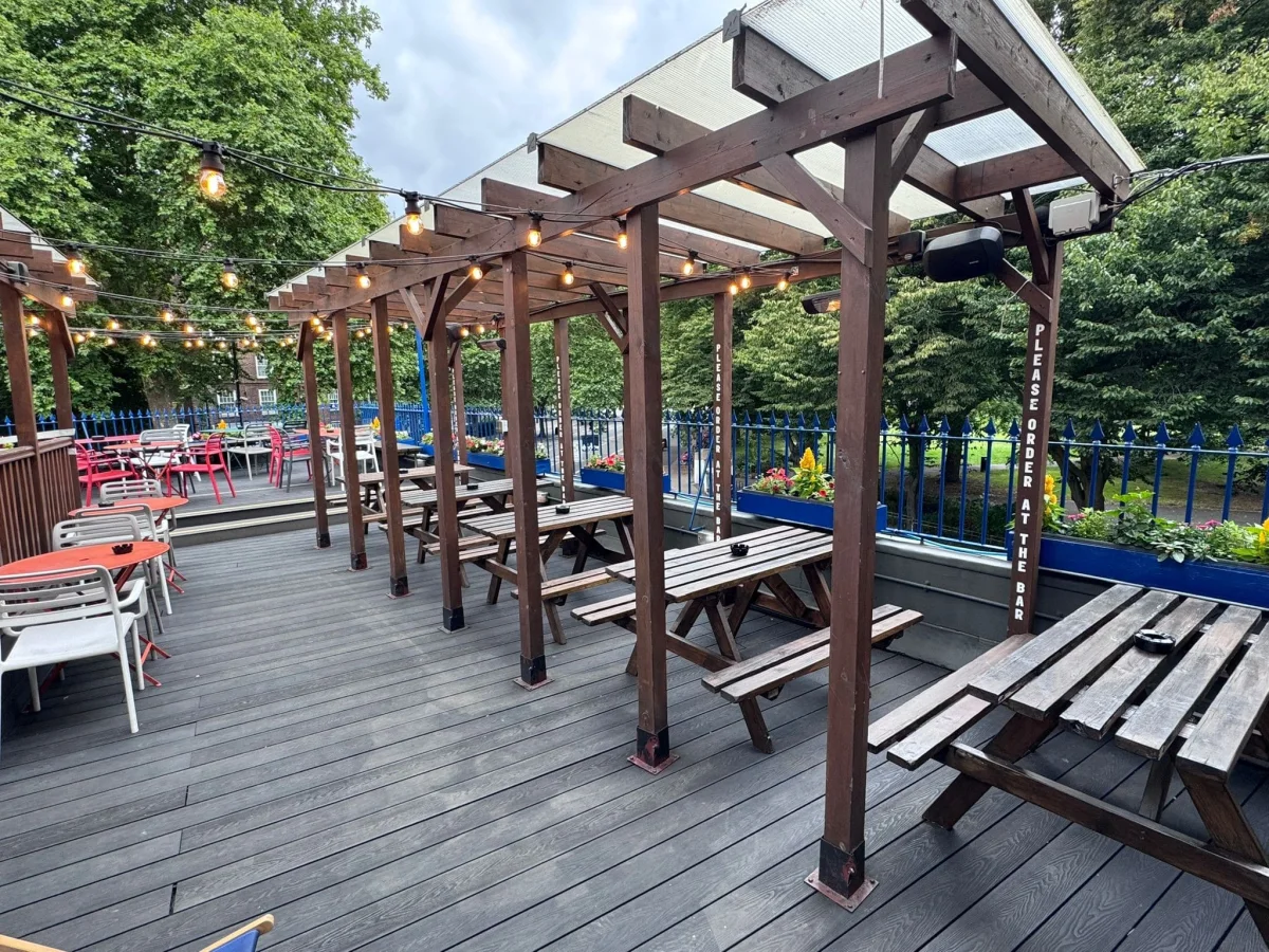 The covered first-floor roof terrace at The Tankard overlooking green trees in Kennington