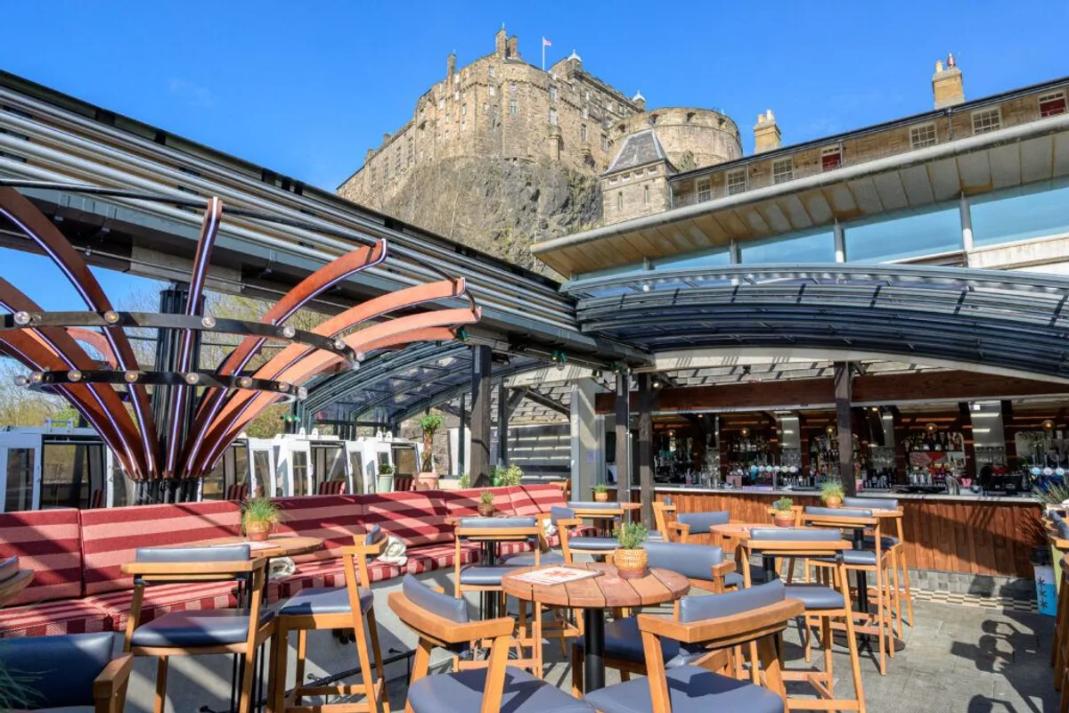 Sunlit rooftop tables at Cold Town House beneath Edinburgh Castle