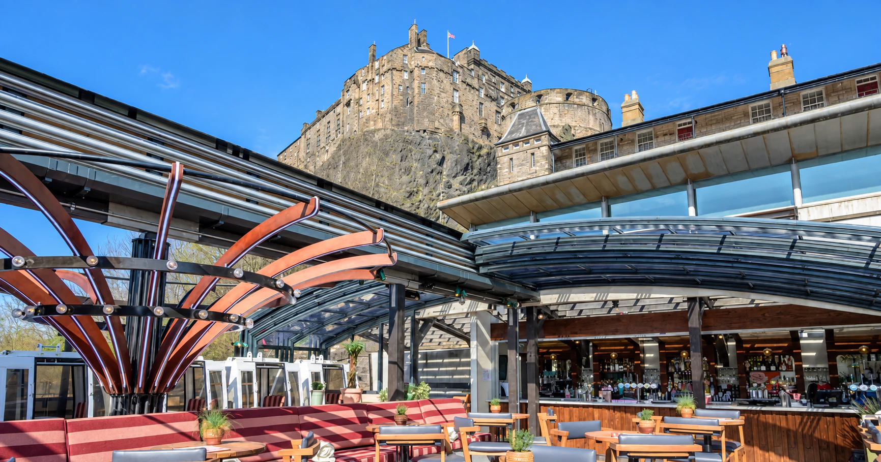 Sunlit rooftop tables at Cold Town House beneath Edinburgh Castle