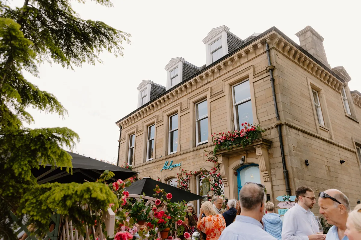McLarens exterior and flowering garden terrace with guests.