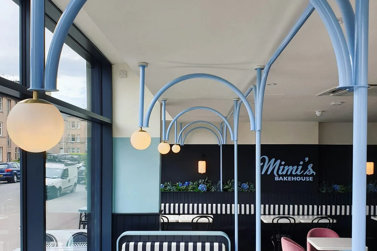Blue arched lighting frames, striped seats and cafe tables at Mimi's Comely Bank.