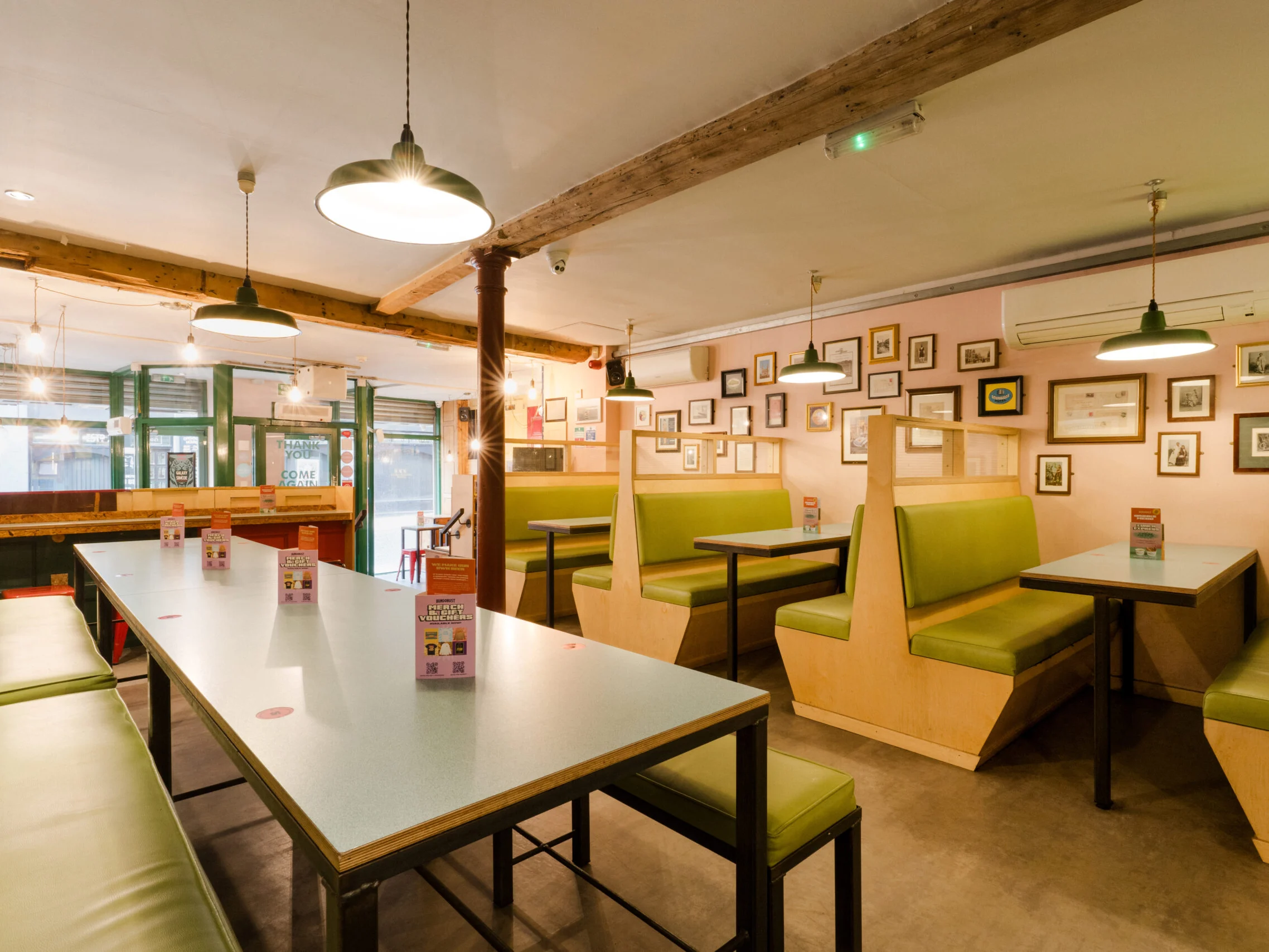 Tables and green booth seating inside Bundobust Leeds.