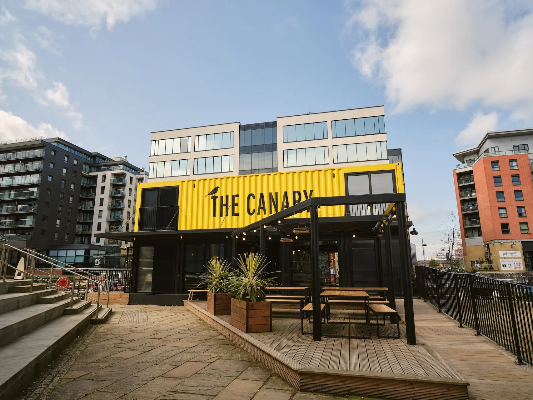 The Canary Leeds Dock entrance and outdoor tables.