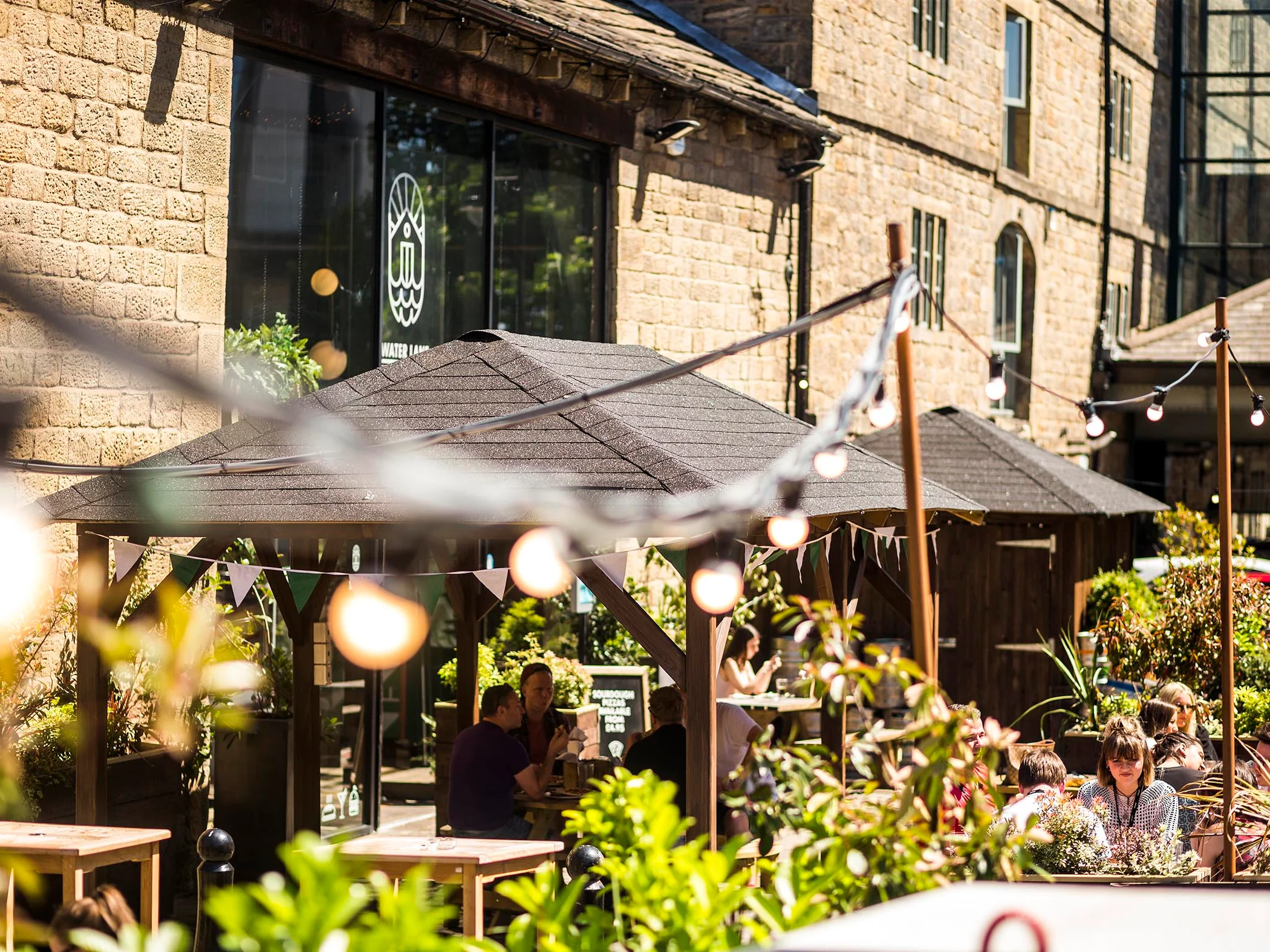Outdoor tables and garden planting at Water Lane Boathouse.