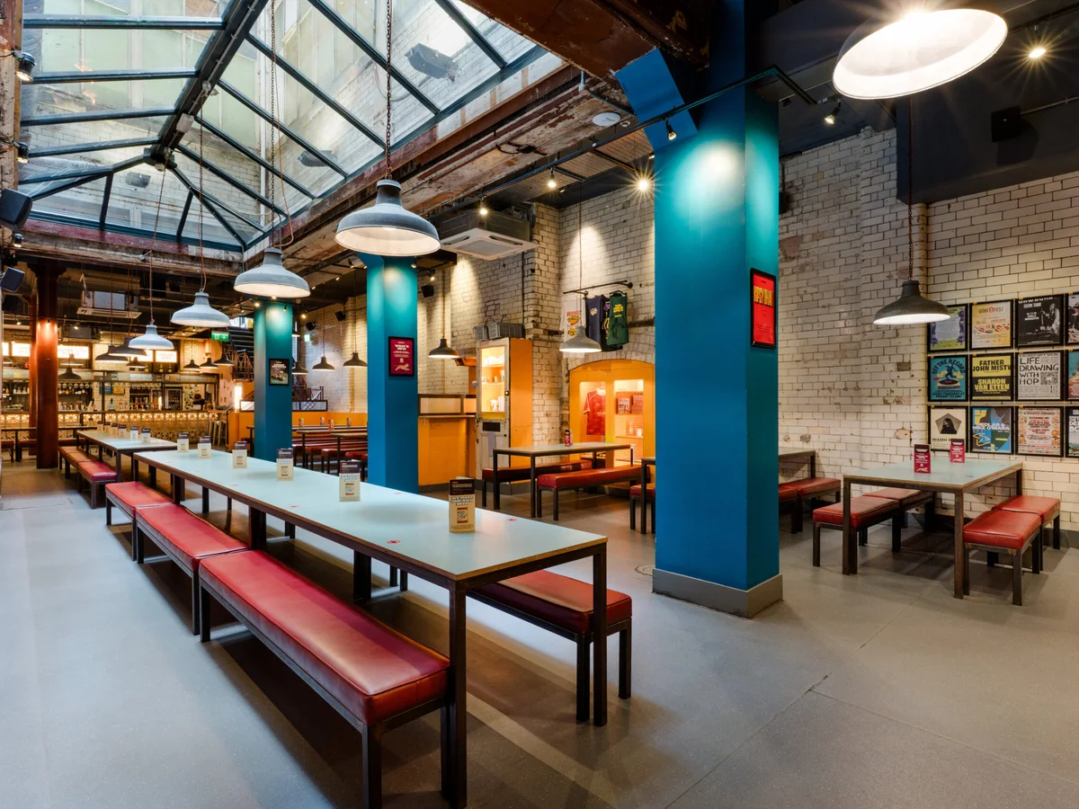 Tables beneath the glass atrium at Bundobust Manchester Piccadilly