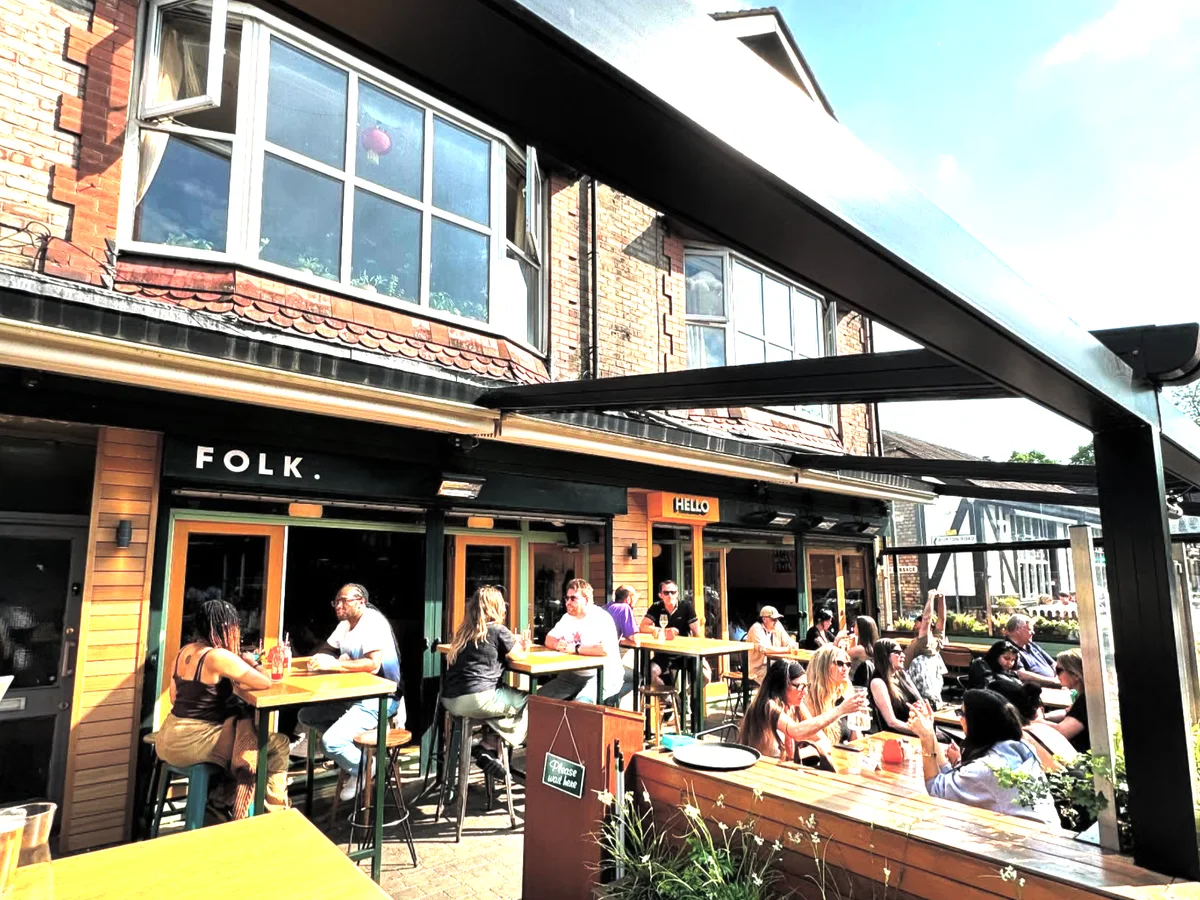 Guests dining on the sunny front terrace at Folk Didsbury
