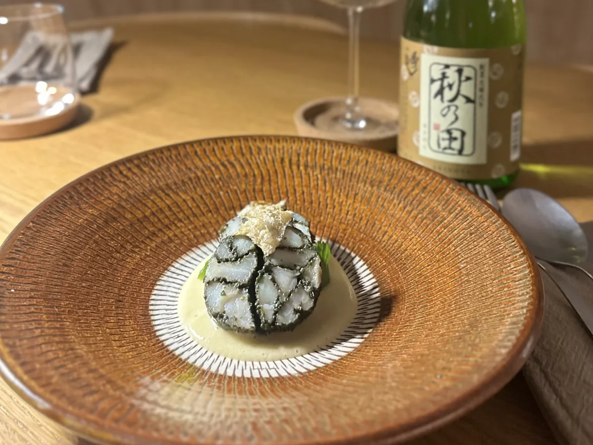 A plated Japanese dish with sake at Suzume Manchester
