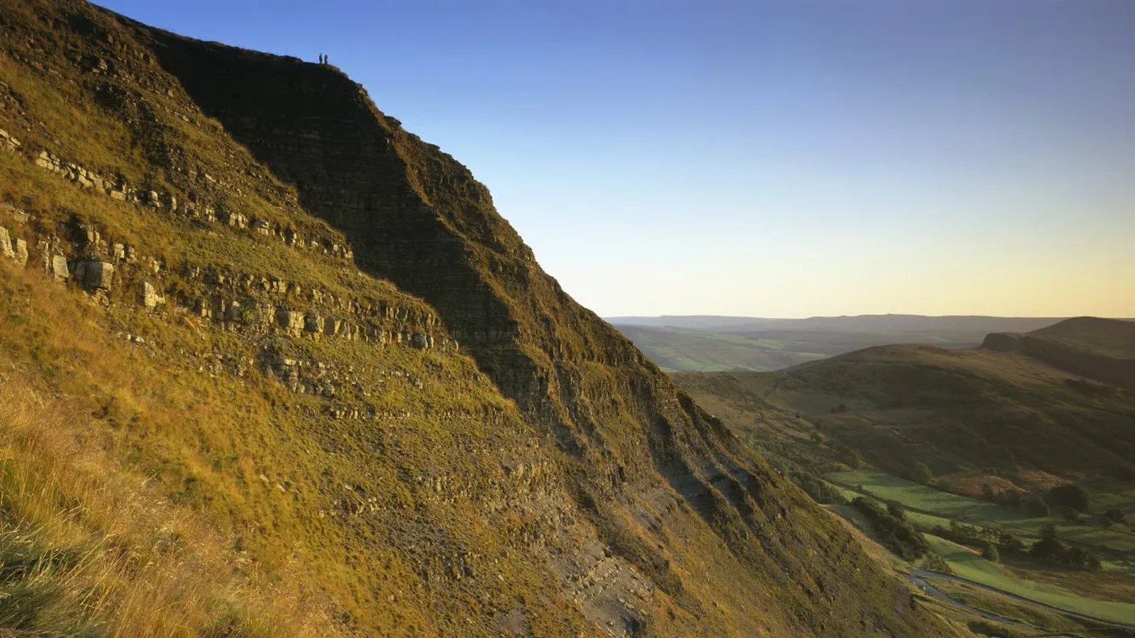 Sunlit slopes of Mam Tor above the valley